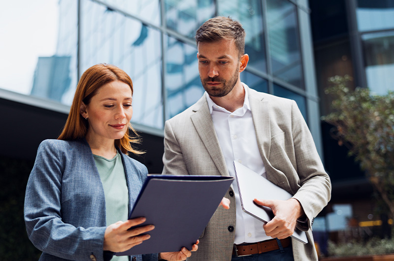 Reduce IBM Costs, Control Sub-Capacity Risk, and Negotiate With Confidence. Two colleagues sharing a document