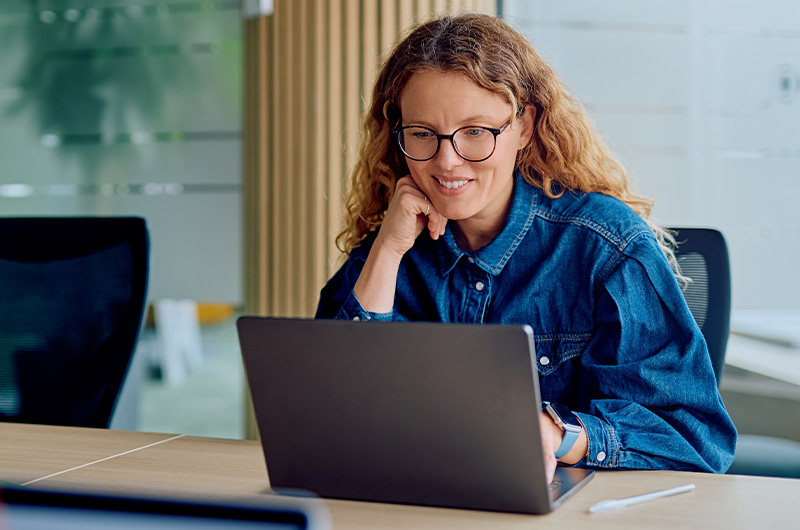 Take Control of Software, SaaS, AI, and Cloud Costs. Woman working on laptop
