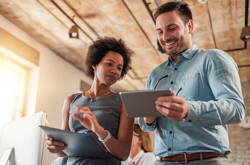 Take Control of Software, SaaS, AI, and Cloud Costs. Two colleagues working on a tablet