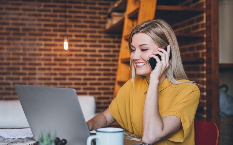 Woman on phone and laptop